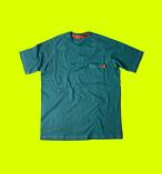 Imagem de camiseta verde escura com bolso na altura do peito esquerdo e fundo de cor de verde neon